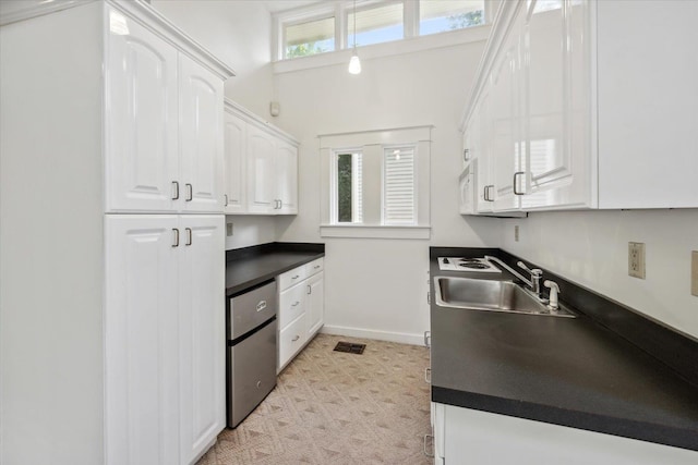 kitchen with white cabinetry, a wealth of natural light, and sink