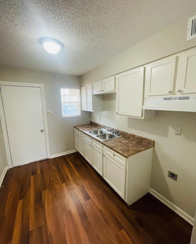 kitchen featuring white cabinetry, sink, a textured ceiling, and dark hardwood / wood-style flooring