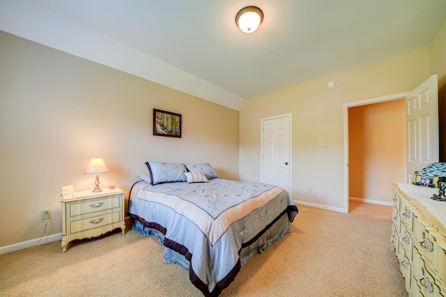 bedroom with light carpet and lofted ceiling