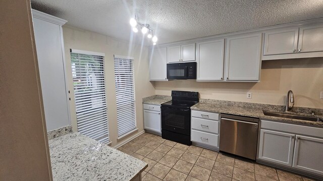 kitchen featuring light tile patterned floors, a textured ceiling, black appliances, gray cabinets, and sink