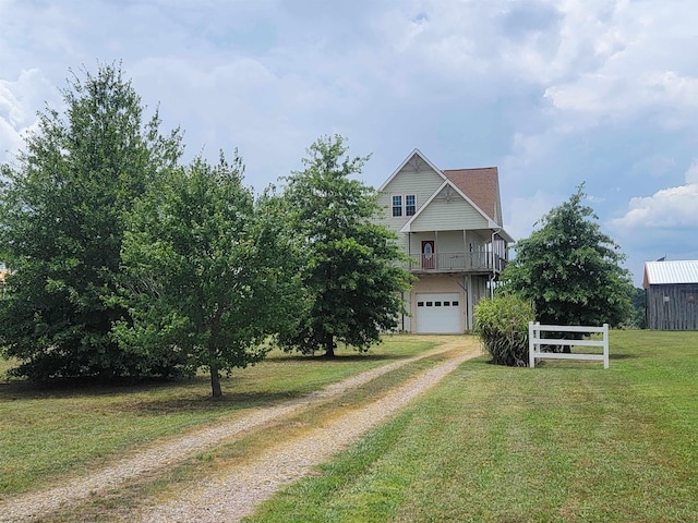 view of front facade featuring a garage, a balcony, and a front yard