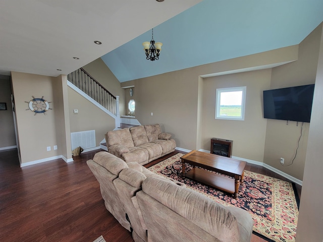 living room with dark wood-type flooring, a chandelier, and vaulted ceiling