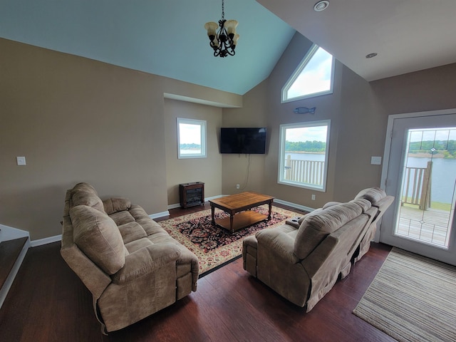 living room with dark wood-type flooring, an inviting chandelier, and a wealth of natural light