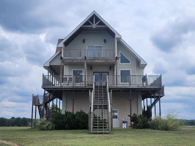 back of property featuring a balcony and a yard