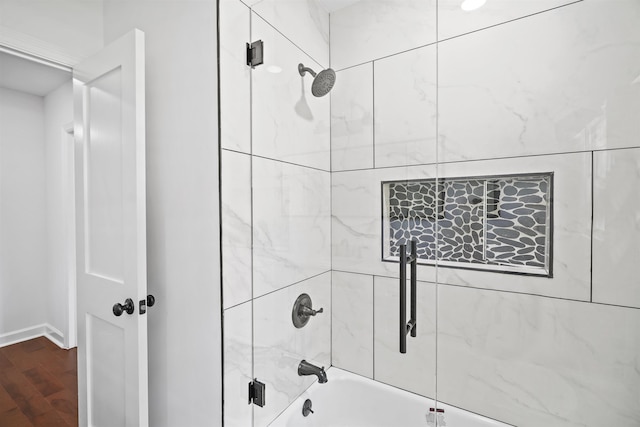 bathroom with tiled shower / bath and wood-type flooring