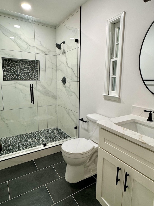 bathroom with a shower with door, toilet, tile patterned flooring, and vanity