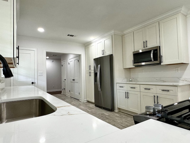 kitchen featuring sink, light wood-type flooring, white cabinetry, and stainless steel appliances