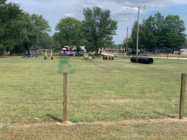 view of home's community with a playground and a yard