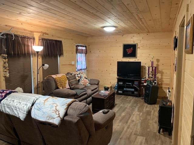 living room featuring wooden walls, hardwood / wood-style floors, and wooden ceiling