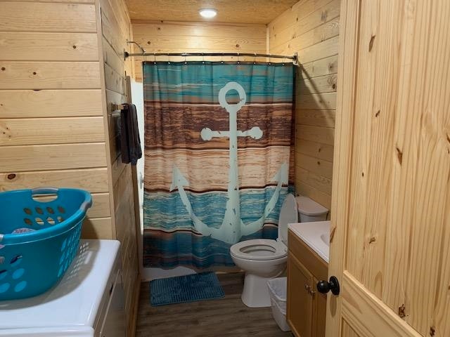 bathroom with wooden walls, toilet, hardwood / wood-style floors, and vanity