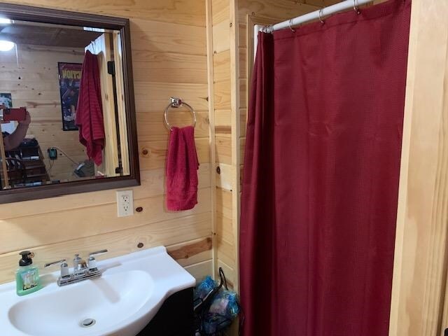 bathroom with sink and wooden walls