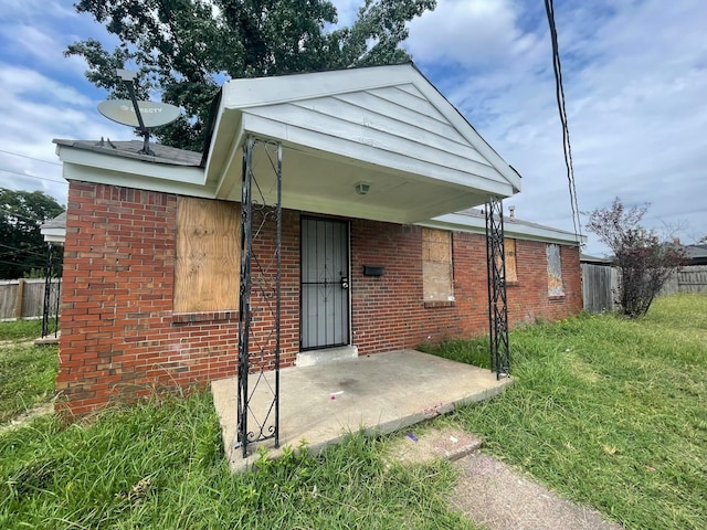 rear view of property featuring a lawn