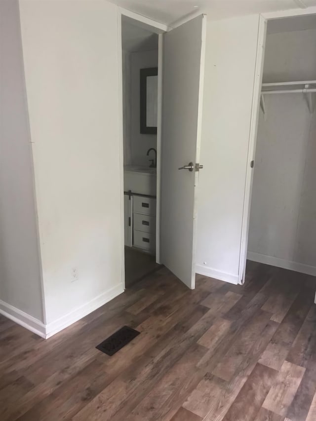 unfurnished bedroom featuring sink and dark hardwood / wood-style flooring