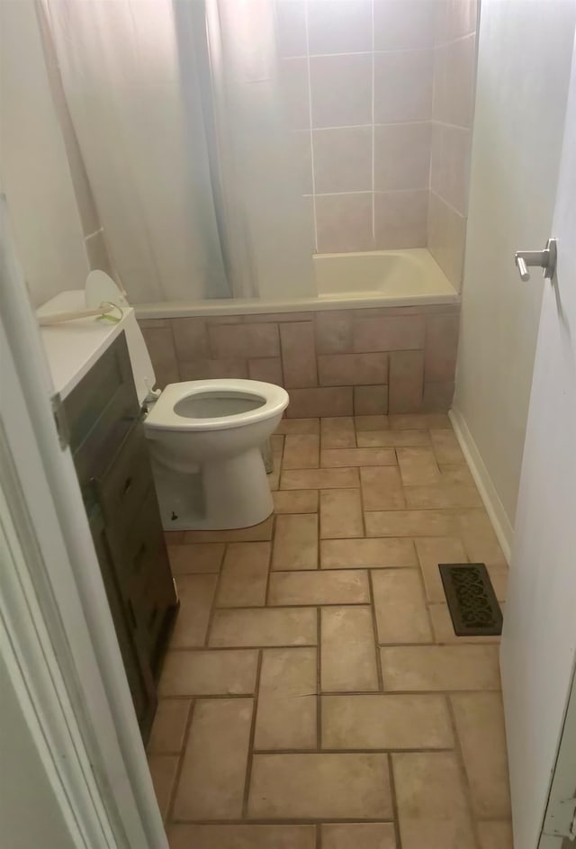 full bathroom with vanity, tiled shower / bath combo, and toilet