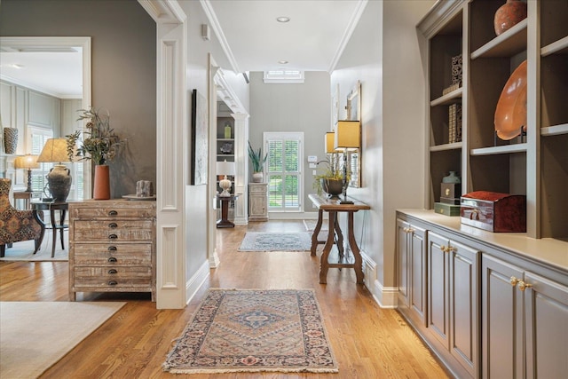 hall with crown molding and light hardwood / wood-style flooring