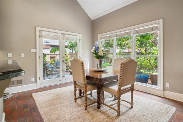 dining space featuring ornamental molding and high vaulted ceiling