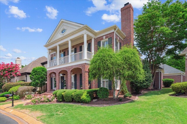 neoclassical / greek revival house with a balcony and a front yard