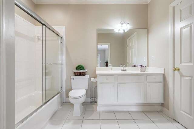 full bathroom with tile patterned floors, vanity, bath / shower combo with glass door, and toilet