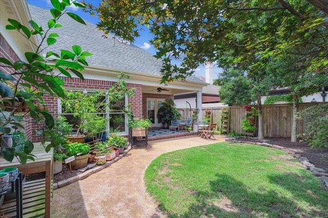 view of yard with ceiling fan and a patio area