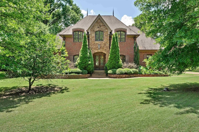 125 Millbury Ln, Eads, TN 38028 - french country style house featuring french doors, brick siding, a front lawn, and a shingled roof