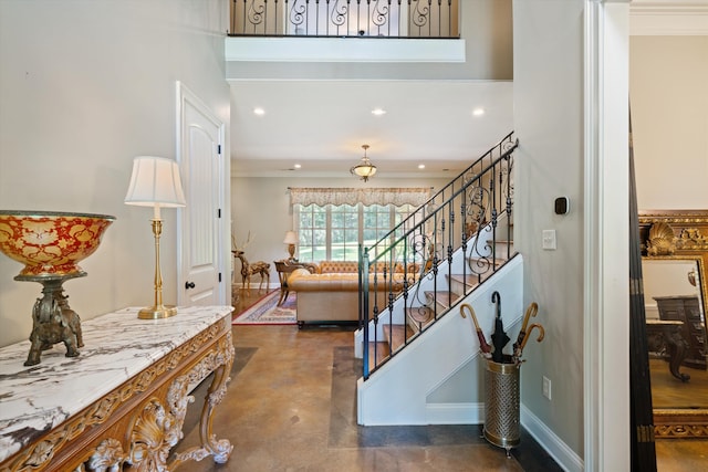 foyer entrance with a towering ceiling and crown molding