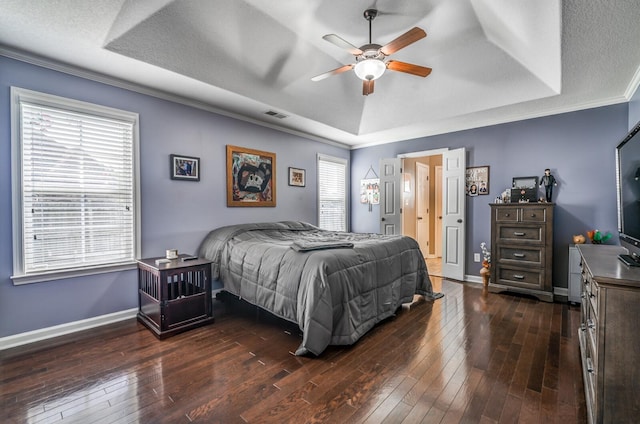 bedroom featuring ornamental molding, dark hardwood / wood-style floors, and a raised ceiling