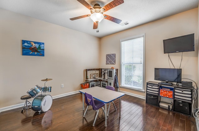 home office with ceiling fan and dark hardwood / wood-style flooring