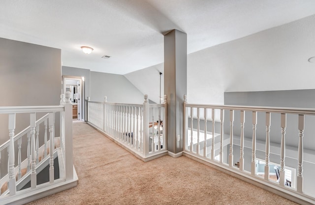 hall featuring lofted ceiling and carpet floors