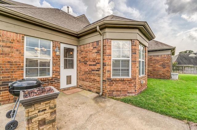 entrance to property with a yard and a patio area