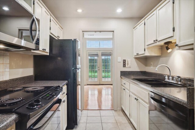 kitchen featuring sink, electric range, black dishwasher, and white cabinetry