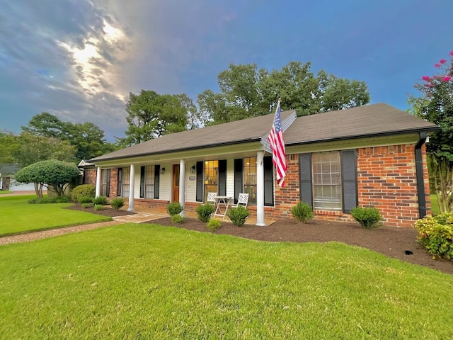 single story home featuring covered porch and a front lawn