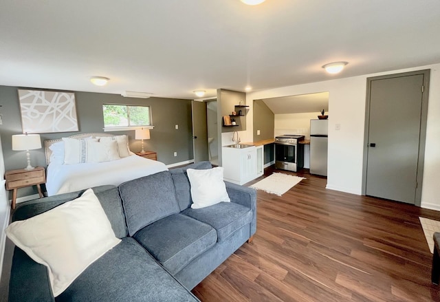 bedroom featuring wood-type flooring, sink, and stainless steel fridge