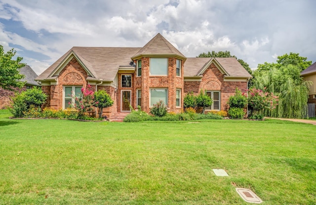 view of front of house featuring brick siding and a front lawn