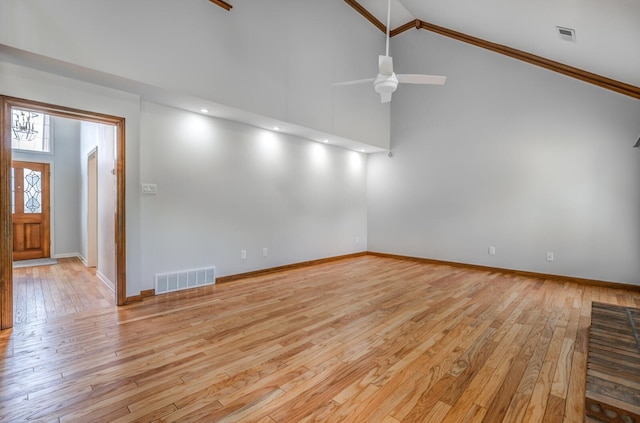 unfurnished living room featuring ceiling fan, ornamental molding, light wood-type flooring, and high vaulted ceiling