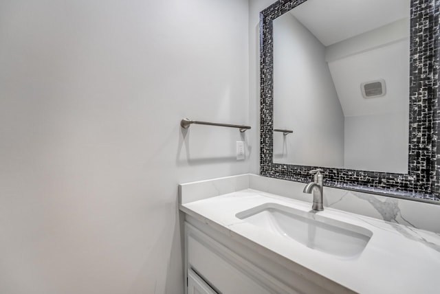 bathroom featuring vaulted ceiling and vanity