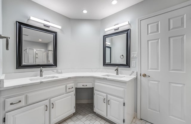 bathroom with double vanity, a shower stall, a sink, and recessed lighting