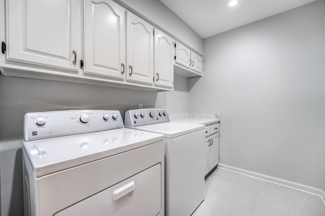 laundry room featuring cabinets, independent washer and dryer, and light tile patterned floors