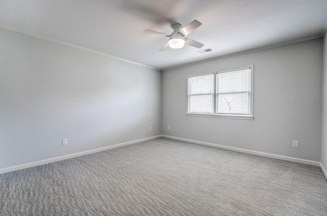 carpeted empty room featuring ceiling fan, visible vents, ornamental molding, and baseboards