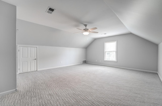 additional living space featuring ceiling fan, light colored carpet, visible vents, baseboards, and vaulted ceiling