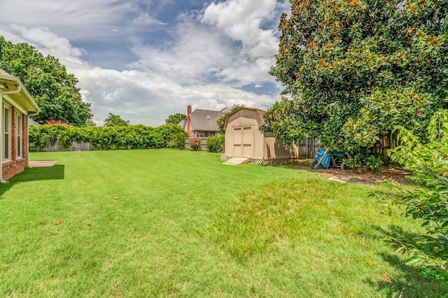 view of yard featuring an outbuilding, a fenced backyard, and a storage unit