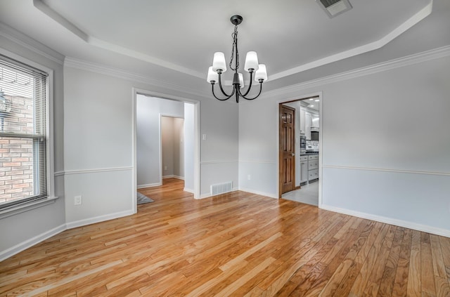 unfurnished dining area featuring light wood-style floors, visible vents, a raised ceiling, and a chandelier