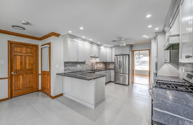 kitchen featuring white cabinets, ceiling fan, appliances with stainless steel finishes, a peninsula, and a sink