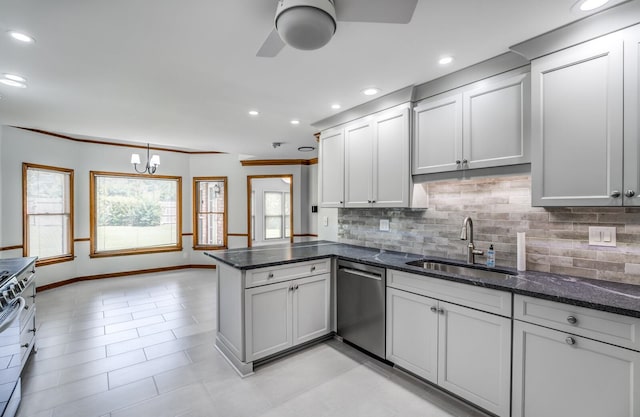 kitchen with kitchen peninsula, ceiling fan with notable chandelier, sink, appliances with stainless steel finishes, and light tile patterned floors