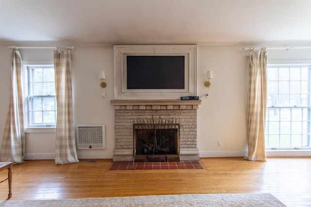 unfurnished living room with ornamental molding, light hardwood / wood-style flooring, and a brick fireplace