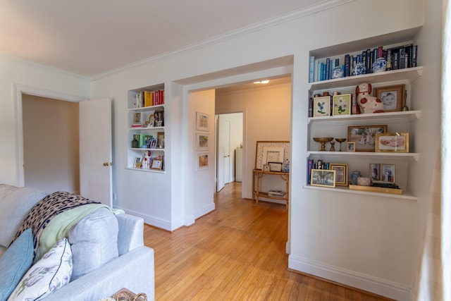 interior space featuring light hardwood / wood-style floors, ornamental molding, and built in shelves