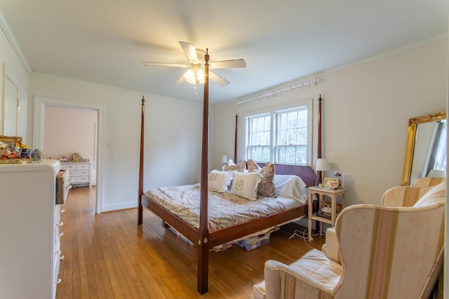 bedroom with ornamental molding, ceiling fan, and light hardwood / wood-style floors