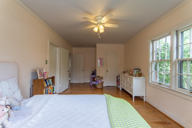 bedroom with hardwood / wood-style flooring, ornamental molding, and ceiling fan