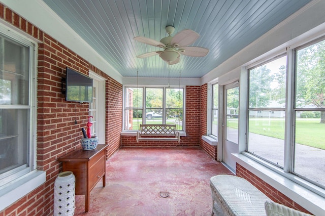 unfurnished sunroom featuring a wealth of natural light and ceiling fan