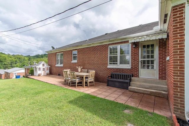 back of house with a patio area and a lawn