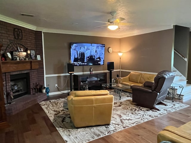 living room featuring ornamental molding, a fireplace, ceiling fan, and hardwood / wood-style floors